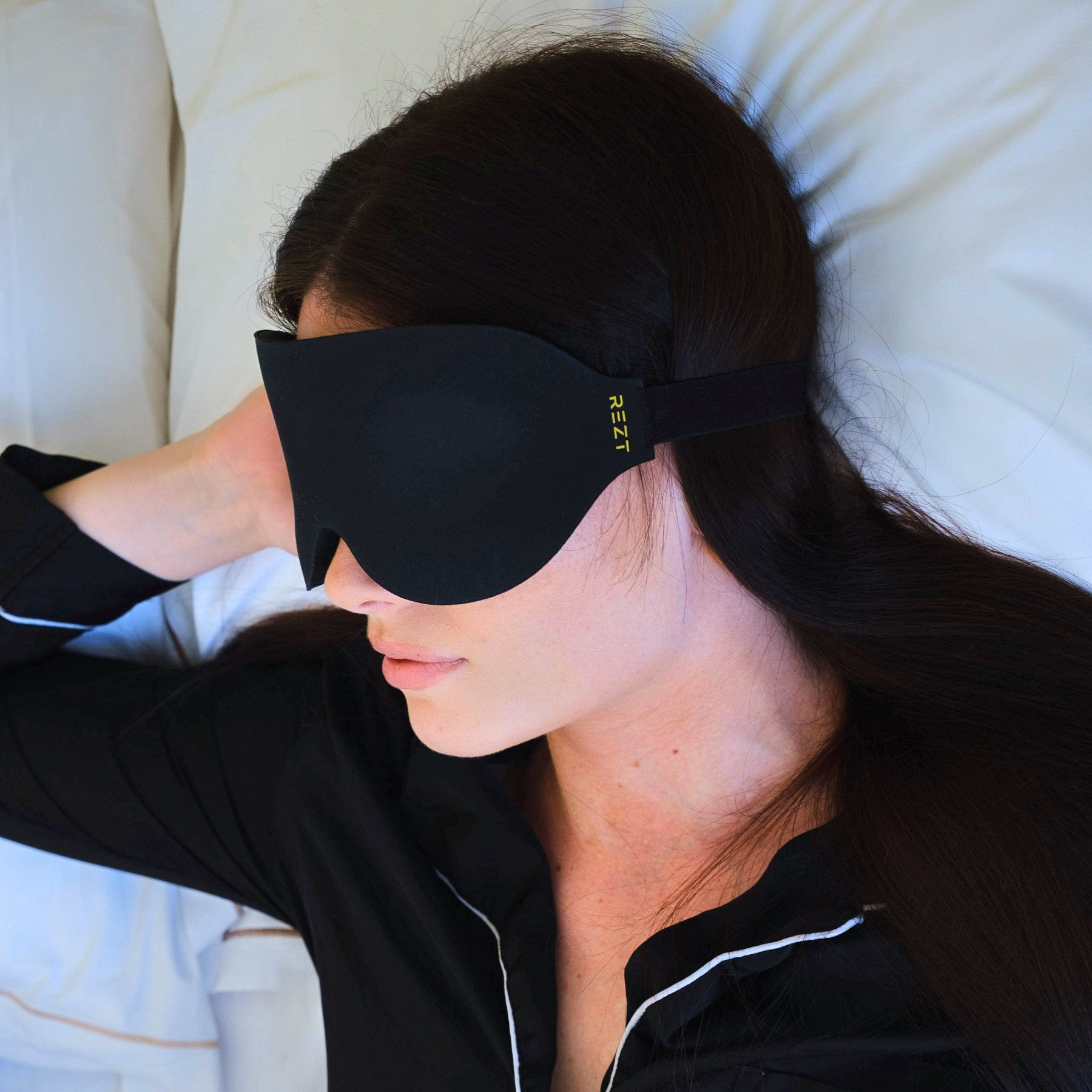 Sovande kvinna med Rezt sovmask - Optimal mörkläggning för djupare sömn.