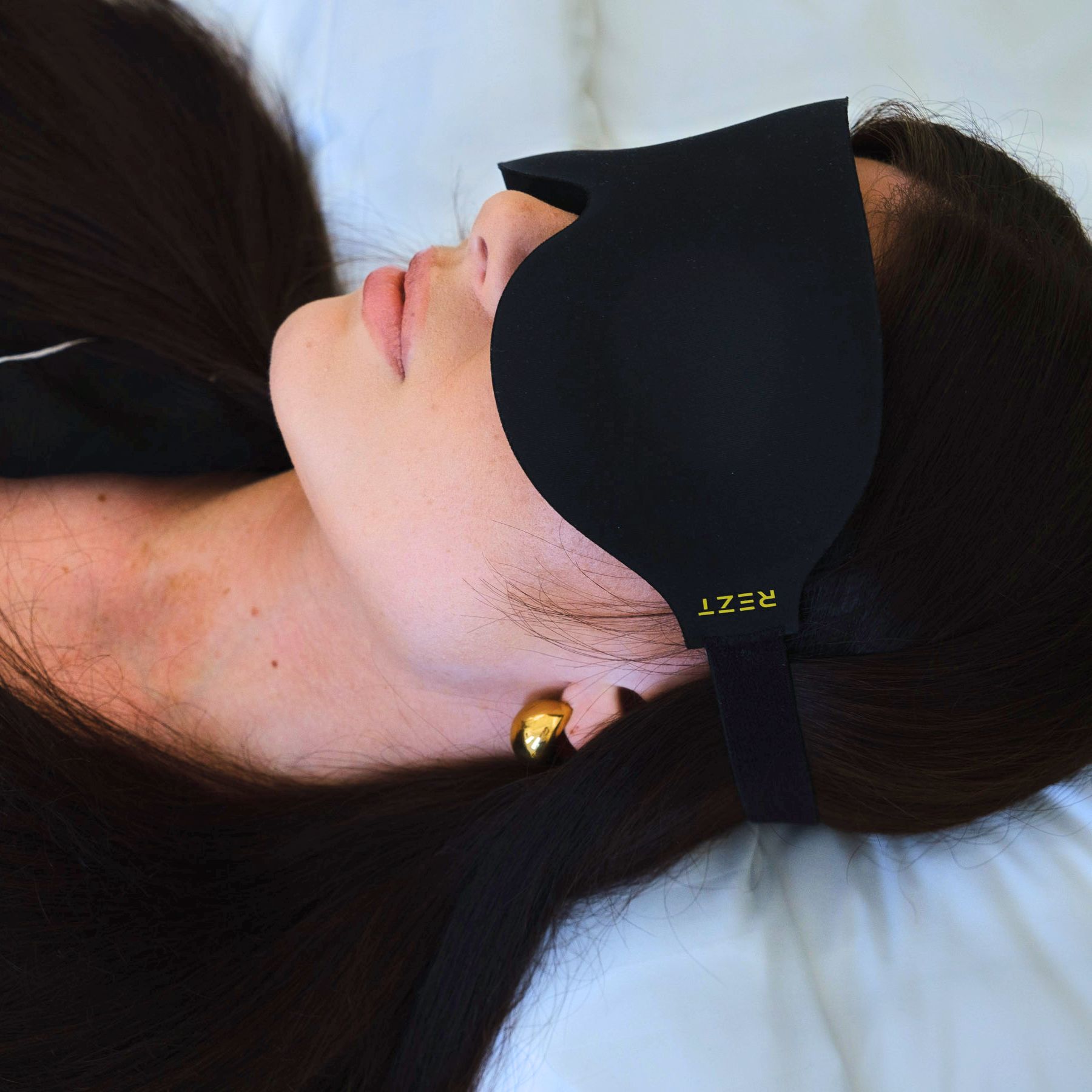 Liggande kvinna med Rezt sovmask - Stilren och funktionell för effektiv vila